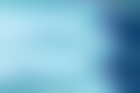 A light blue and dark blue gradient background with a soft blend and blurred areas.の写真素材