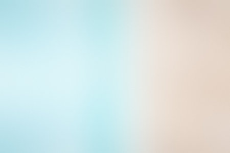 A soft, blurred gradient of light blue and peach creates a gentle, serene abstract background.の写真素材