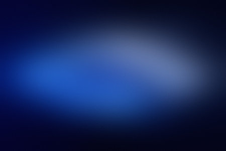A deep blue blurred gradient background with a bright central light effect and soft edges.の写真素材