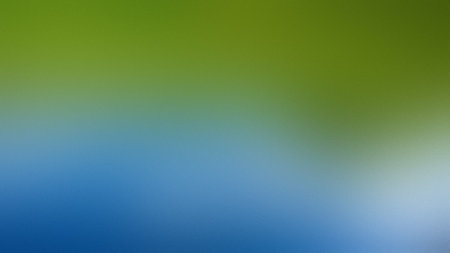 A soft gradient blends green at the top with blue at the bottom, with white highlights.の写真素材