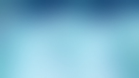 A bright light blue softly blurred gradient background with a subtle, diffused texture.の写真素材