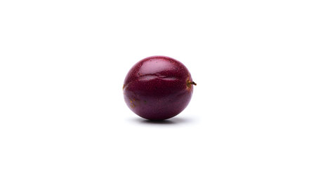 A single ripe purple passion fruit rests on a clean white surface. Clear details and vibrant colo...
