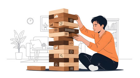 A person plays a tower block game, carefully removing a block with data icons from a tall stack.の写真素材