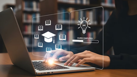 Hands typing on laptop showing online course completion with graduation cap and books. Clear deta...
