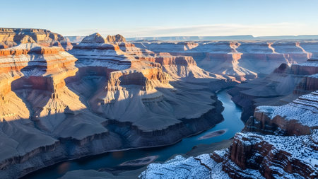 Majestic grand canyon panorama with snow-dusted formations and the winding colorado river under a clear skyの写真素材