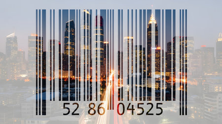 A barcode is superimposed over a city skyline at dusk, featuring glowing skyscrapers and light...の写真素材
