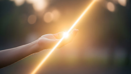 Diagonal showing a diagonal beam of bright golden sunlight shines through an open hand held...