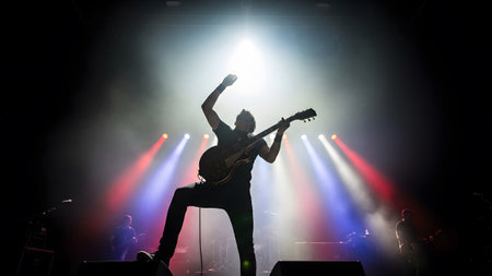 (3846) showing silhouette of a rock musician energetically playing guitar on a concert stage...の写真素材