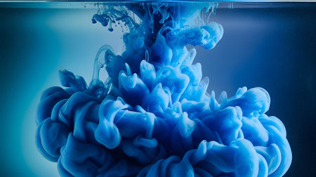 showing blue ink dissolving in clear water creating dynamic abstract shapes and fluid...の写真素材