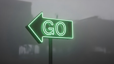 Water showing green neon go sign pointing left in foggy outdoor setting with water droplets....