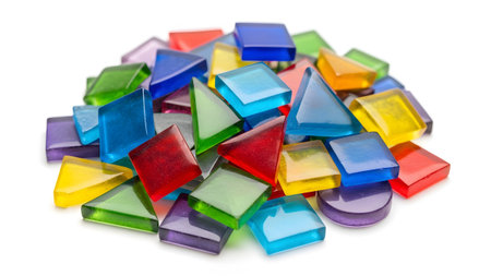 A pile of colorful translucent geometric glass pieces including squares triangles and circles is...