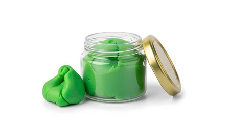 Green modeling clay fills a clear glass jar with a gold lid, next to a sculpted lump of the same...