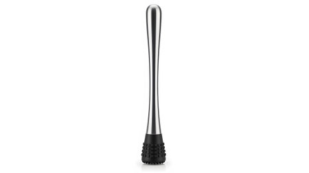 A polished stainless steel cocktail muddler with a black textured rubber head stands upright on...