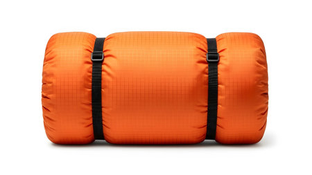 showing rolled orange sleeping bag with black straps and buckles on a white background....