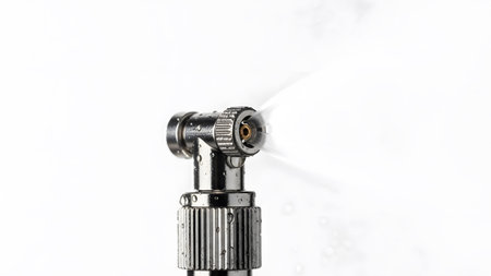 Spraying showing close up of a chrome dental drill head spraying water with droplets.