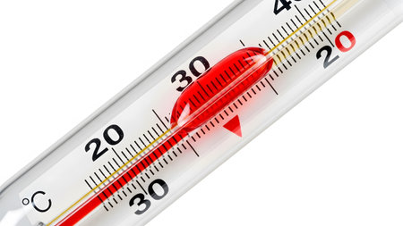 Close up of a glass thermometer with red mercury indicating a temperature of 33 degrees Celsius...