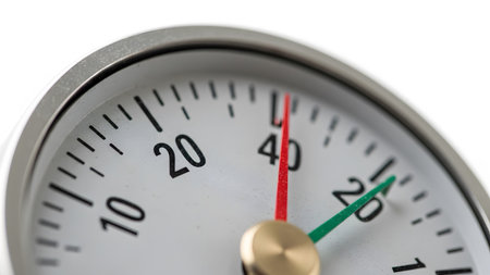 Extreme close-up of a white gauge dial with black numerical markings and two colored indicator...