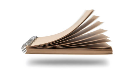 A brown kraft paper spiral bound notebook fanning pages in motion against a white background.の写真素材