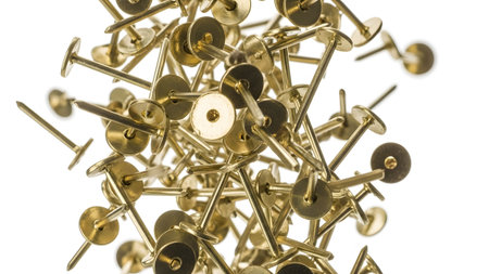 Push showing scattered golden thumb tacks and push pins with sharp points in a cluster.