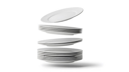 Multiple showing multiple white ceramic plates stacked and levitating with a shadow on a white...