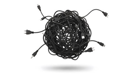 A messy ball of black electrical cords and various connectors is suspended against a white...の写真素材