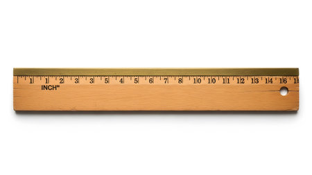Edge showing wooden ruler with brass edge showing inch markings isolated on white.