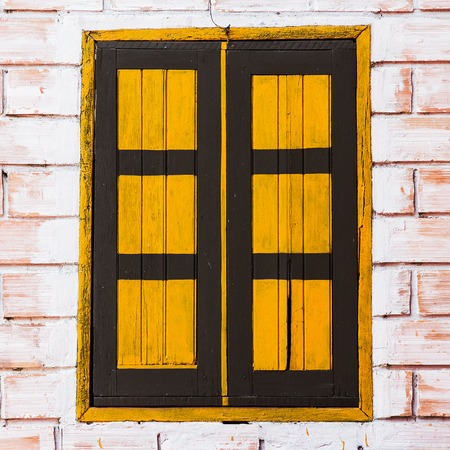 Vintage window on yellow cement wall の写真素材