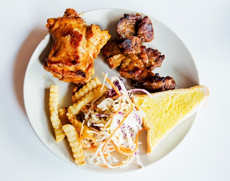 Fried pork chop, chips and vegetable saladの写真素材