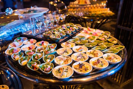 Cocktail party with variety of desserts and food decorated in spoons arranged in orderly fashionの写真素材