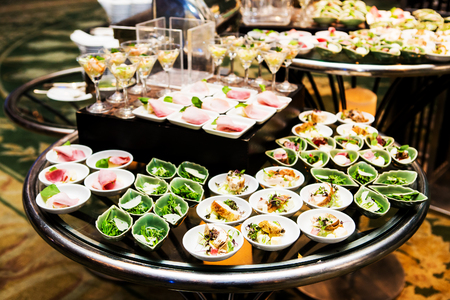 Cocktail party with variety of desserts and food decorated in spoons arranged in orderly fashionの写真素材