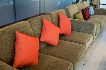 Pillows on the brown sofa in hotelの写真素材