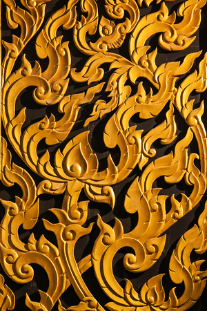 Ancient golden carving wooden window of Thai temple. Thailandの写真素材