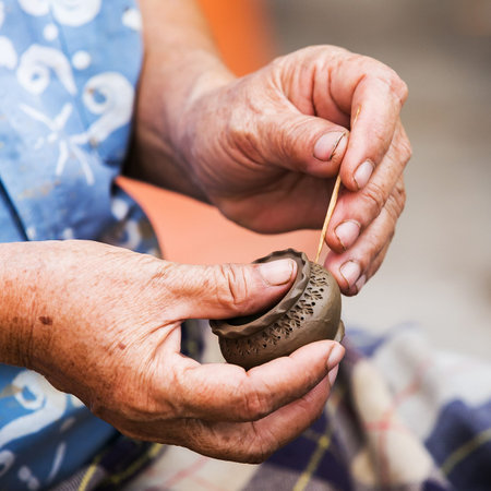 Workers producing handmade art vase earthenware at market.