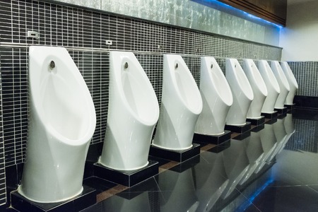 white urinal in men public toilet with black wall tileの写真素材