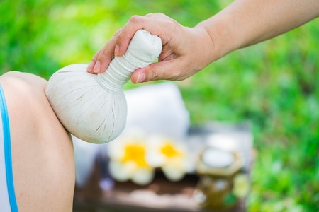 Female hands with tray of spa products over green reeds on riverの写真素材