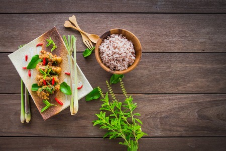 Stir-fried chicken with basil and rice on wood tableの写真素材