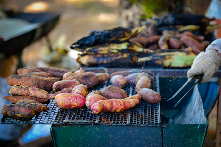 Grilled sweet potatoes on the charcoal grill plateの写真素材