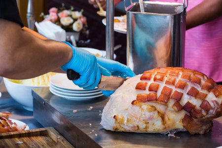 huge chunks of pork roasting on a spitの写真素材