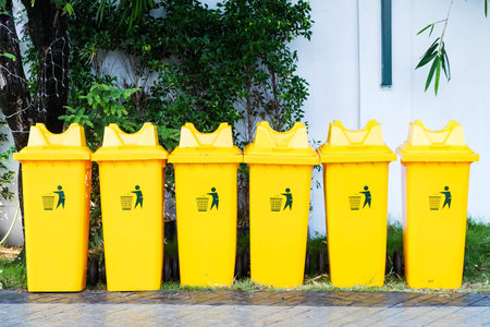 Large yellow trash bin placed 6 side by side.