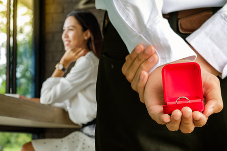 Diamond ring in red box on hand  for couple