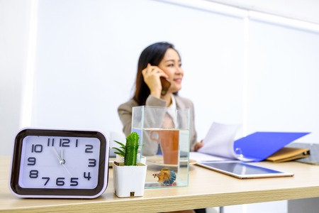 alarm clock tells the time that business women are calling to eat with friends.の写真素材