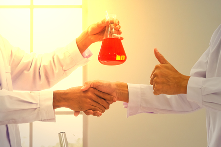 Man handshake to welcome the success of scientific chemical research.の写真素材