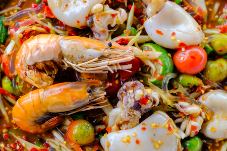 Som Tam Seafood (Spicy Papaya Salad) with salted crab, on wooden table ( Thai food)の写真素材