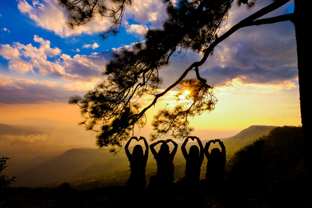 Silhouette of happy young couple in love looking view sunset on the mountain. Romantic couple in loveの写真素材