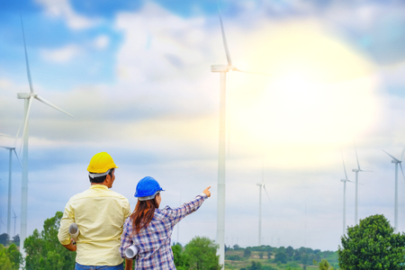 A team of male and female engineers together develop wind power to generate electricity.の写真素材