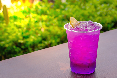 Butterfly pea and lemon juice in a glass put on sack fabric and grunge wooden backgroundの写真素材