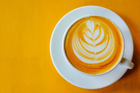 Latte Coffee art on the wooden table yellowの写真素材