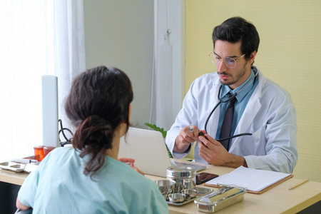Front view of Caucasian male doctors and female patients, talking about illness and taking notes in...