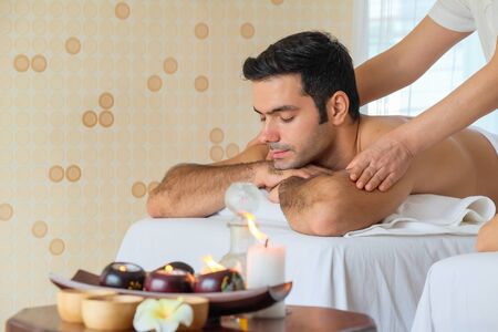 Beautiful man  during massage with essential oil in room spaの写真素材