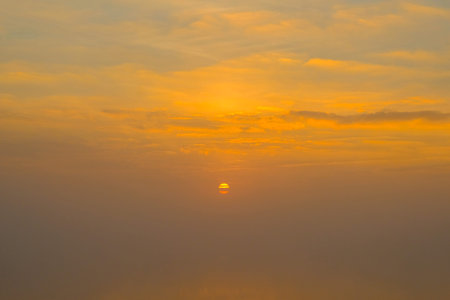 Gorgeous scenic of the strong sunrise with silver lining and cloud on the orange sky